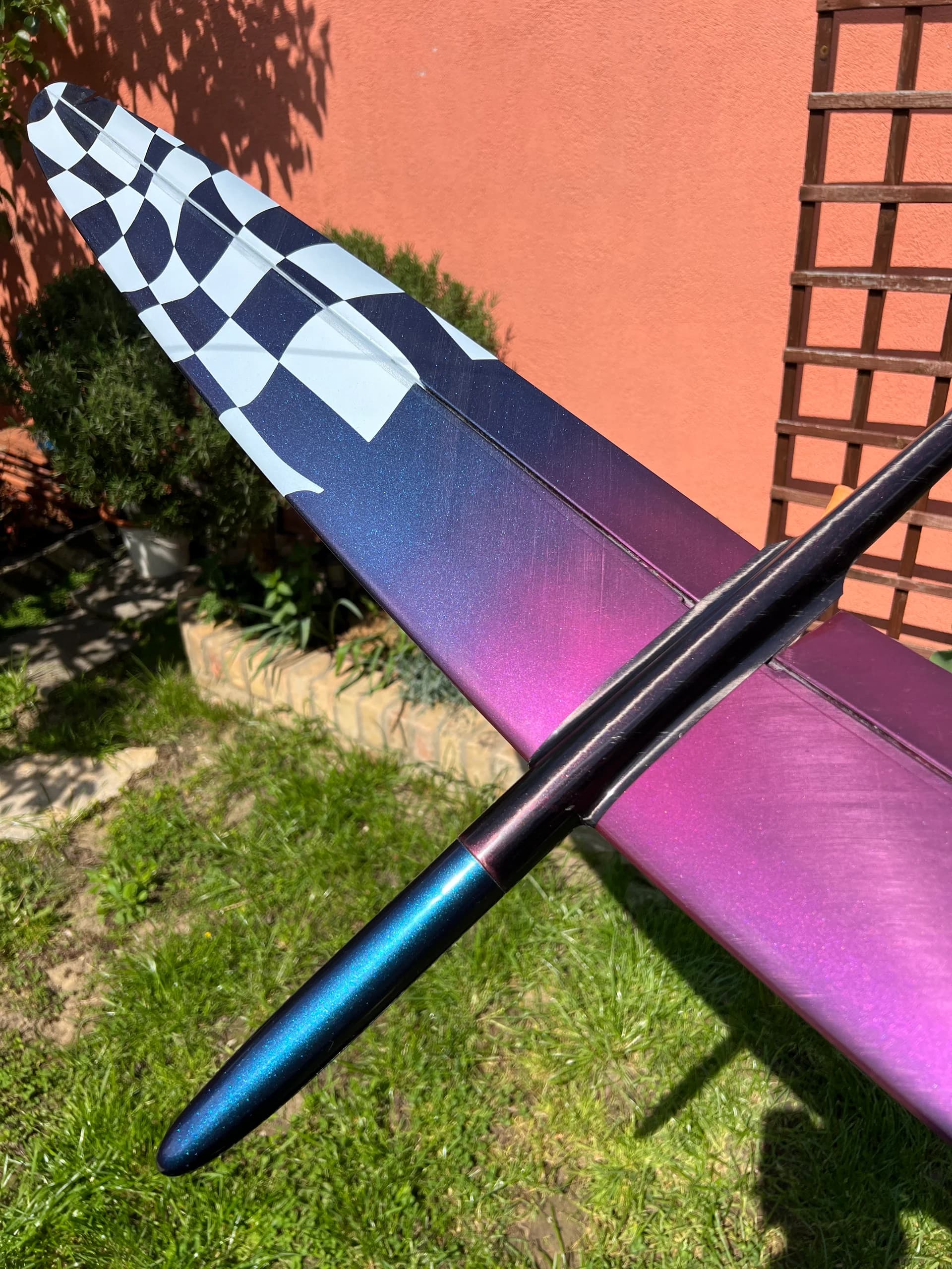 D1S fuselage across a pink and blue wing with a white checkerboard tip