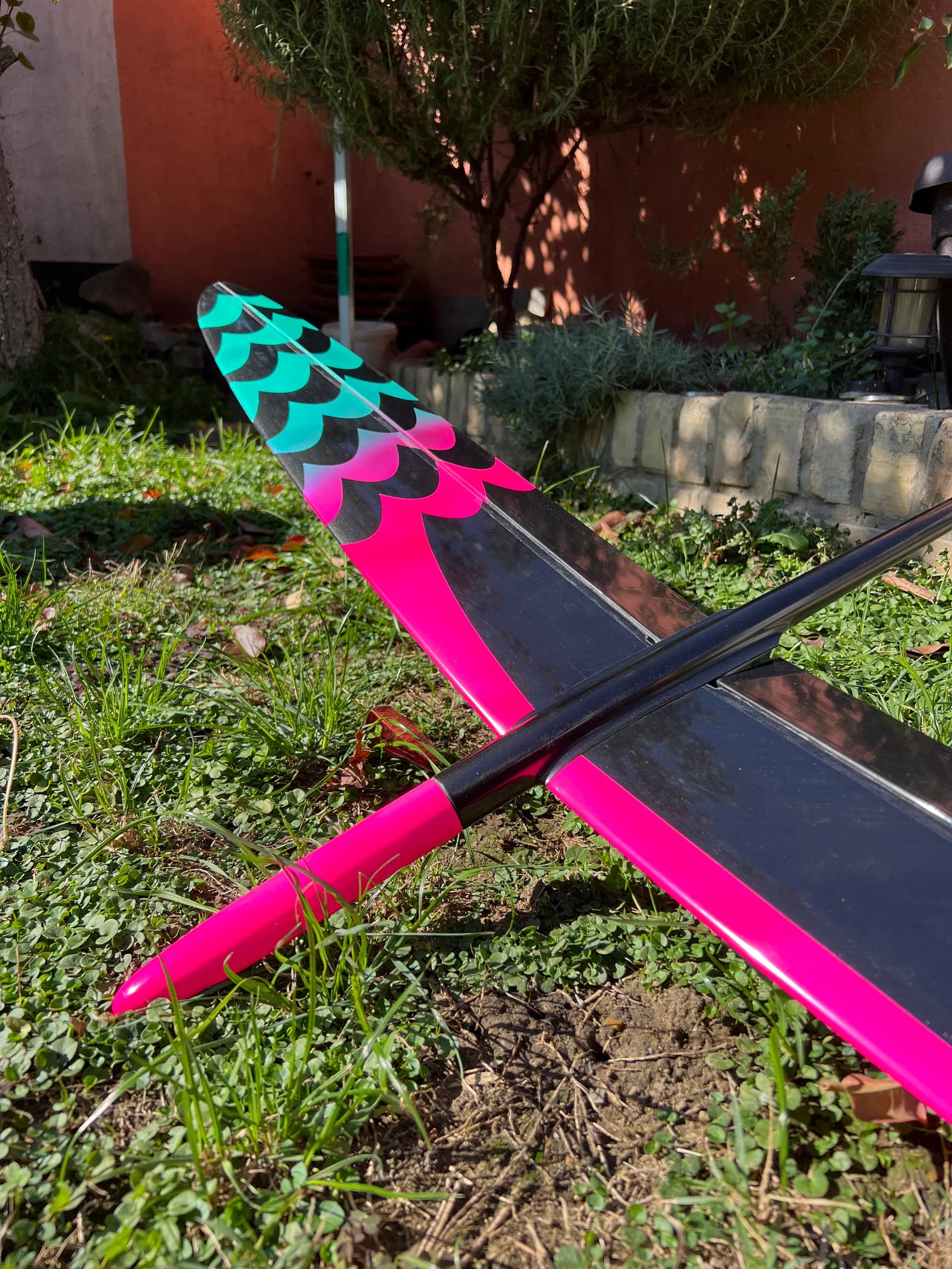 Pink D1S glider with a turquoise checkerboard wingtip